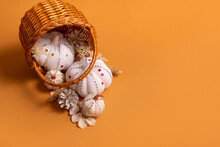 White Decorative Hand Made Pumpkins With Shiny Stones And Pine Cones In Basket On Colored Background. Thanksgiving Day Concept