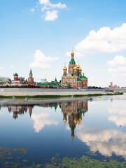 Wall Mural - view of Cathedral of the Annunciation of the Blessed Virgin Mary reflects in water surface of Malaya Kokshaga river in Yoshkar-ola city on sunny summer day