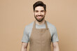 © ViDi Studio - Young fun smiling happy caucasian man barista barman employee wear brown apron work in coffee shop looking camera isolated on plain pastel light beige background studio Small business startup concept