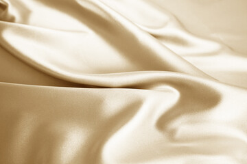 Wall Mural - Beige cream silk satin. Soft folds. Light brown color elegant background for design. Silky smooth fabric surface. Close-up.
