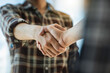 © crizzystudio - Handshake of businesspeople. Male and female hand makes a handshake in the office.