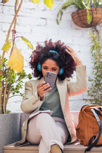 Black Businesswoman Using Cellphone And Making Notes