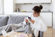 © deniskomarov - Sick young woman with flu orders her medicine online at home from her bank card. Ill girl with cold chatting with physician in medical app.