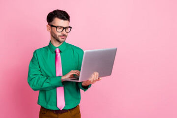 Poster - Photo of serious confident guy wear green shirt spectacles typing modern device empty space isolated pink color background