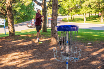 Disc golf, a flying disc sport played using rules like golf, being played by a middle aged man on a nine hole course in  Ashbridges Bay Park in Toronto’s Beaches neighbourhood in late August.
