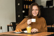 © ADDICTIVE STOCK - Happy young woman having breakfast in restaurant