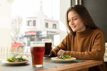 Happy Woman Enjoying Beer In Restaurant