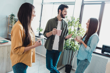 Poster - Portrait of three attractive cheerful people specialists discussing developing project drinking latte at workplace workstation indoors