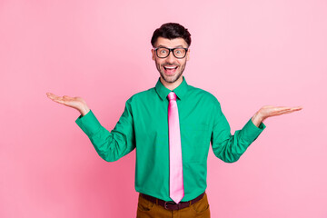 Sticker - Closeup photo of young handsome guy smiling surprised with prices holding hands choosing best deal isolated on pink color background