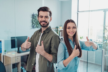 Sticker - Portrait of two attractive cheerful leaders partners showing thumbup advert at workplace workstation indoors