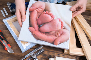 the master demonstrates a photo of children's legs printed on canvas and stretched on a stretcher.