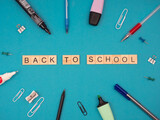 back to school - napis z drewnianych kostek, przedmioty biurowe, spinacze, długopis, zakreślacz