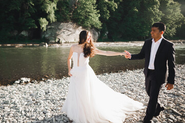 Wall Mural - Wedding couple holding hands, groom and bride together on wedding day