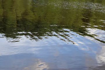 Wall Mural - Water surfaces with waves and ripples and the sunlight reflecting at the surface.