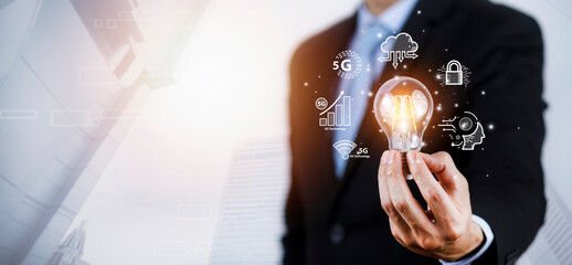 Poster - Businessman holding light bulbs, ideas of new ideas with innovative technology and creativity, concept creativity with bulbs that shine glitter, businessman holding illuminated light bulb, innovation