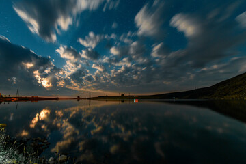 Wall Mural - Night landscape. Beautiful lake in the night under  starry sky and long exposhure clouds.
