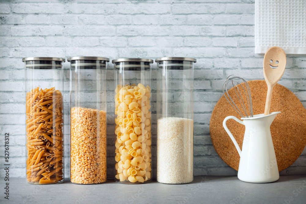 pasta, rice, grains, beans in transparent glass jars on the kitchen countertop, zero waste kitchen, eco food storage, kitchen order
