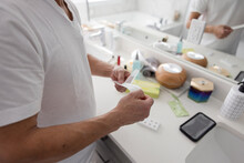 Close Up Man Opening Covid Rapid Antigen Test In Bathroom