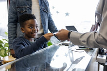 Smiling Boy Customer Paying Barber With Credit Card In Barber Shop