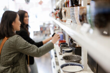 Women Friends Hopping For Mugs In Home Goods Store