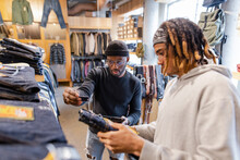 Men Shopping For Jeans In Clothing Store