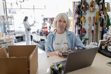 Portrait Confident Female Business Owner Working At Laptop In Pet Stor