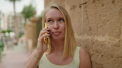 Sticker - Young blonde woman smiling confident talking on the smartphone at street