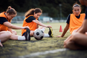 Wall Mural - Female soccer team warming up for the match at stadium.