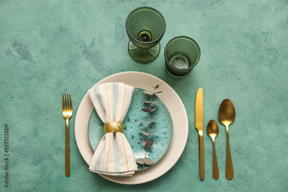 Stylish table setting with eucalyptus branch on green background