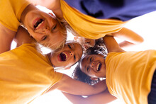 Directly Below Portrait Of Cheerful Multiracial Elementary Schoolgirls Huddling While Standing