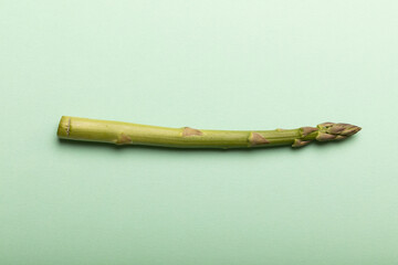 Wall Mural - Directly above view of single asparagus vegetable with copy space over blue background