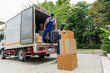 © Tongpool - Professional goods move service use truck carry personal belongings door to door transport delivery handover boxes luggage one by one and keep stack on the floor before transfer to place in house