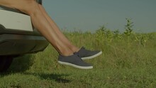 Close-up Of Slim Beautiful Female Legs In Canvas Shoes Dangling From Car Trunk Over Scenic Summer Nature, While Woman Traveler Enjoying Road Trip And Vacations In Countryside.