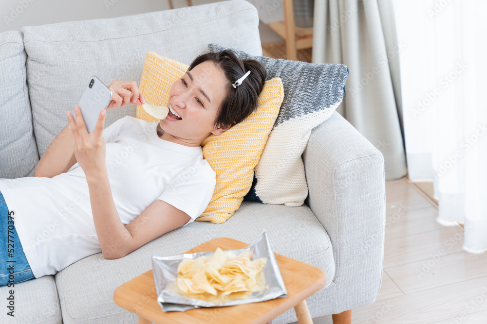 家でだらだらするミドル女性 の Stock フォト | Adobe Stock