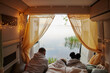 © Johnér - Friends lying in camper van and looking at lake