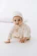 © Ananass - Cute studio portrait of a little newborn which has already begun to crawl. The child laughs and rejoices in his first little steps