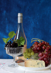 Canvas Print - Still life with wine and grapes. Colorful photo of bottle of rose wine and different sorts of grapes. Seasonal fruit on a table. 