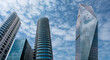 © bahadirbermekphoto - Modern tower buildings or skyscrapers in financial district with cloud on sunny day. bottom view