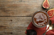Homemade delicious fig jam on wooden table, flat lay. Space for text