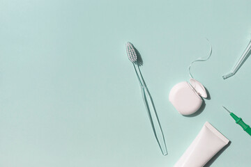 Dental care concept frame with toothbrush, irrigator, tooth floss and toothpaste on the blue background. Copy space