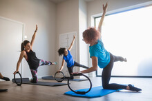 Sporty People With Instructor Exercising With Pilates Ring