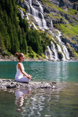 Sticker - A woman practices yoga in the mountains