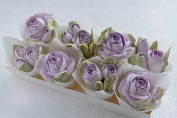 Marshmallow bouquet of flowers in a gift box on a light background, holiday concept