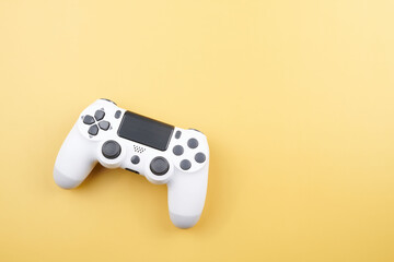 White video game controller, joystick for game console isolated on yellow background. Gamer control device close-up