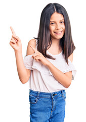 Beautiful child girl wearing casual clothes smiling and looking at the camera pointing with two hands and fingers to the side.