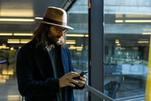 Stylish Male Traveler Using Smartphone In Airport