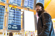 © ADDICTIVE STOCK - Hipster male passenger standing next to airport schedule board