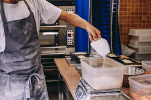 Crop Male Baker Weighing Sugar On Scales In Bakery