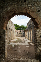 Wall Mural - Entrance with an arch to an ancient church located in Butrint national park, part of UNESCO heritage. Saranda, Albania