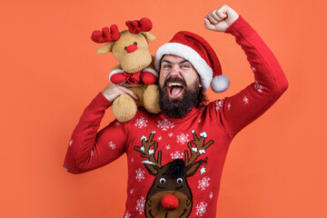 Wall Mural - winter holiday preparations. present and gift shopping sale. happy new year. merry christmas. cheerful bearded man in santa claus costume. hipster celebrate xmas party with reindeer toy. Look at that